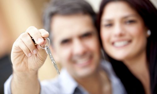 Loving couple holding keys to house or car