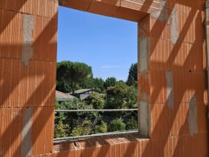 L'esquirey, photo de chantier prise en juillet 2026, vue sur la forêt depuis une fenêtre
